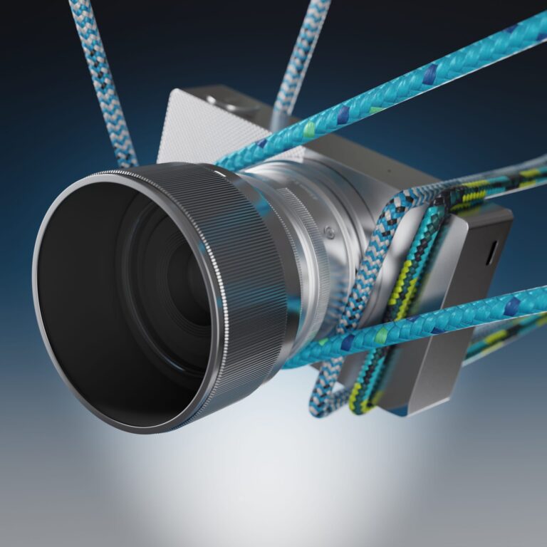Hopeanvärinen Sigma BF -kamera, jonka ympärille on kietoutunut sinisiä ja vihertäviä köysiä tummansinisellä taustalla.